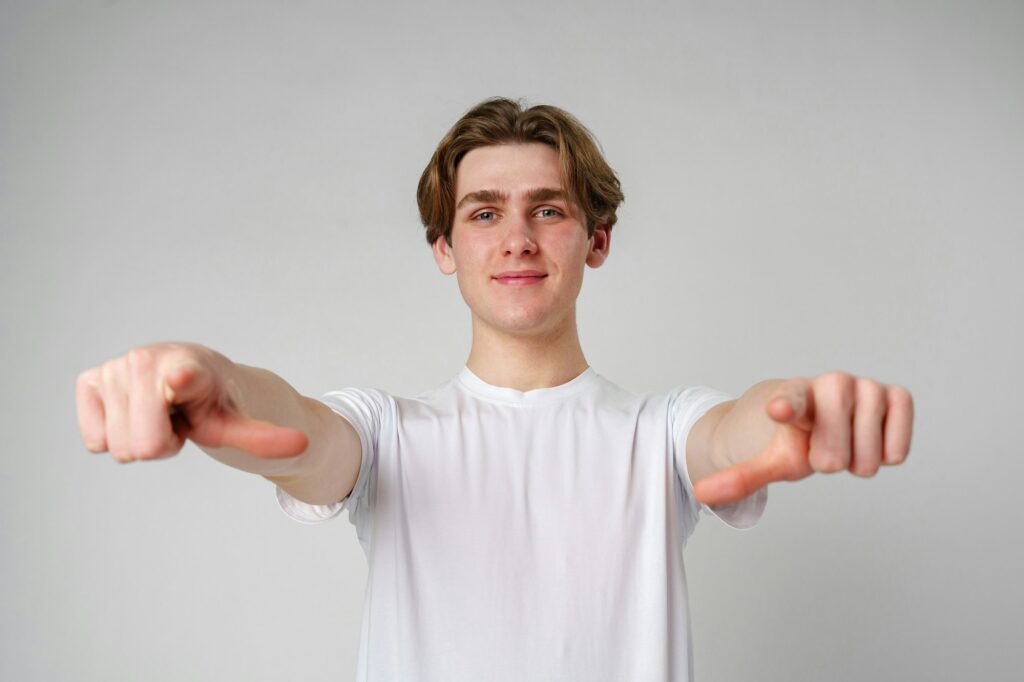 Young Man in White T-Shirt Pointing at Camera